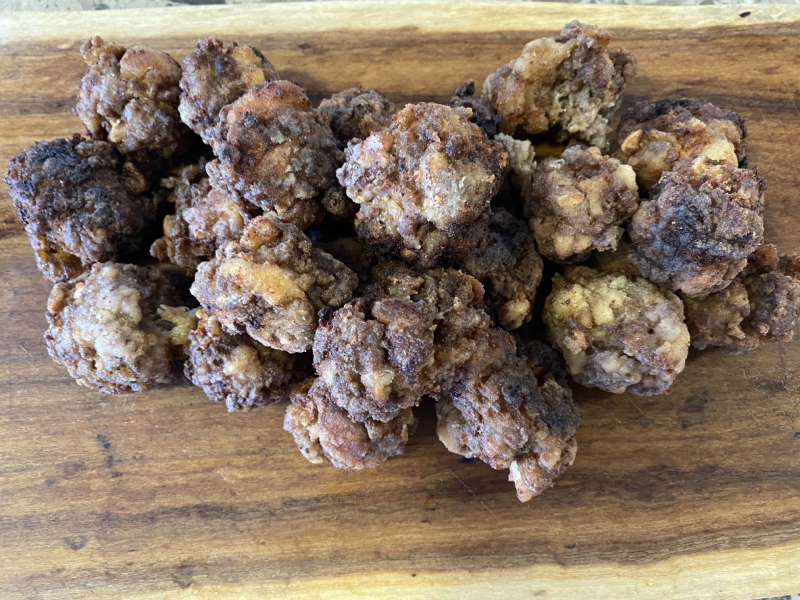 A plate of traditional Greek-style Keftedes, perfectly golden meatballs served on a rustic wooden board, capturing the essence of Mediterranean flavours.