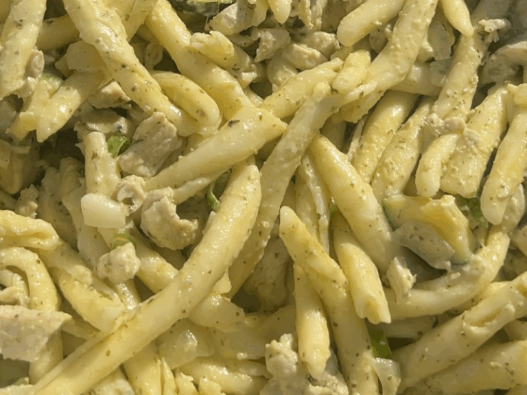 Creamy chicken pesto pasta served in a rustic ceramic bowl with a wooden spoon from The Wooden Koutali.