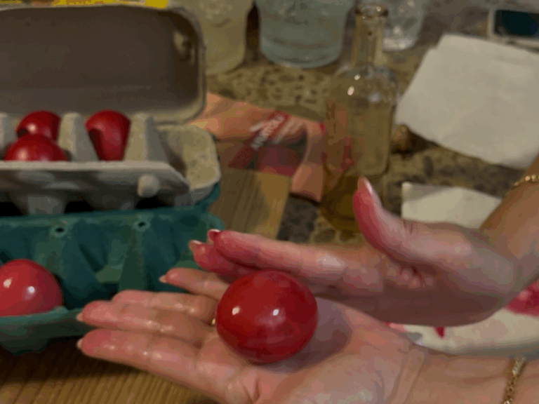 Glossy deep red Greek Easter eggs arranged in a carton, freshly dyed and polished with olive oil.