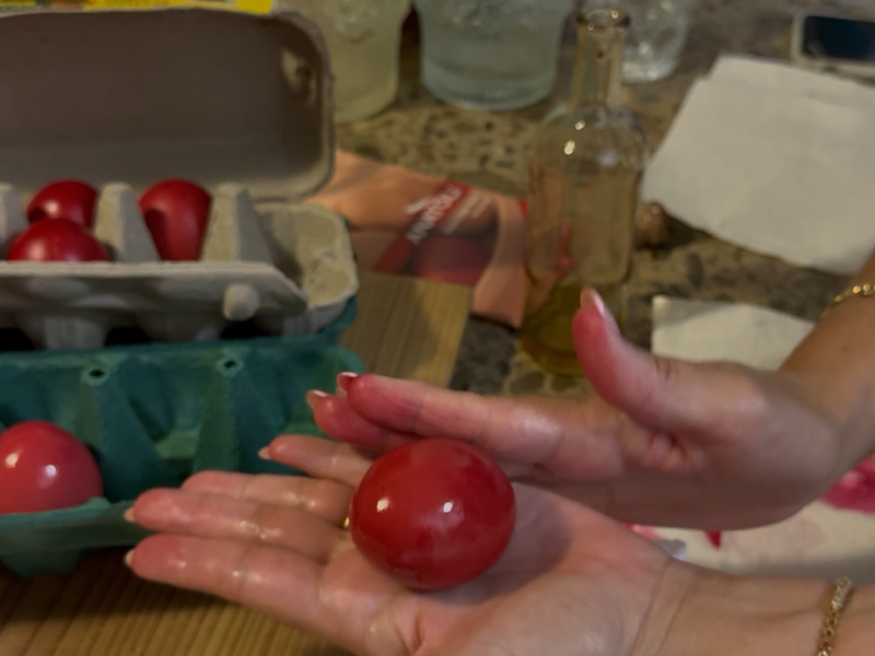Glossy deep red Greek Easter eggs arranged in a carton, freshly dyed and polished with olive oil.